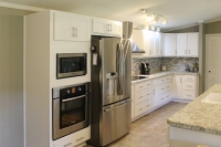 narrow view of painted white kitchen along wall